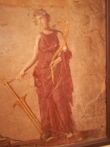 Particolare di affresco pompeiano, conservato al museo archeologico di Napoli, in cui la dea tiene con la destra il timone e con la sinistra la cornucopia